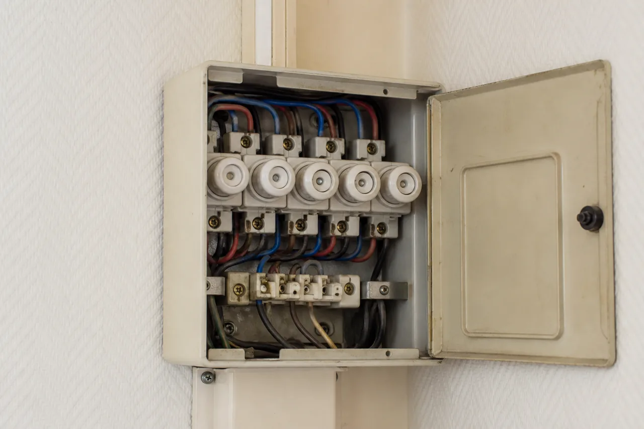 Ancien tableau électrique à fusibles en céramique dans un logement