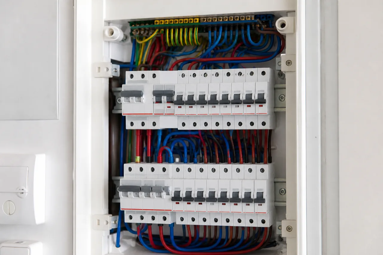 Tableau électrique moderne ouvert montrant les protections et conducteurs visibles